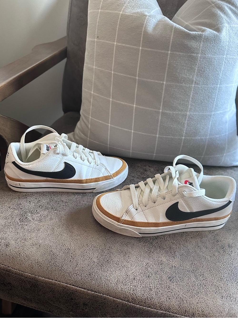 Nike Womans White Leather Low-Top Sneakers with Black Swoosh and Tan Accent.